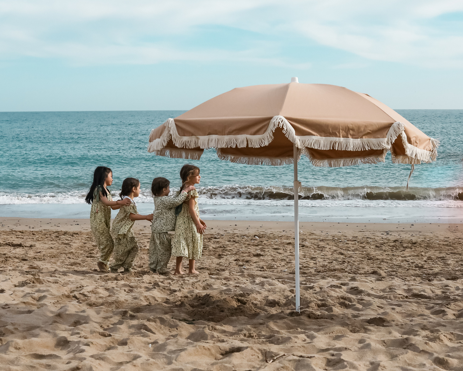 cuatro niñas haciendo una hilera jugando en la playa las casetas del Garraf en barcelona, españa