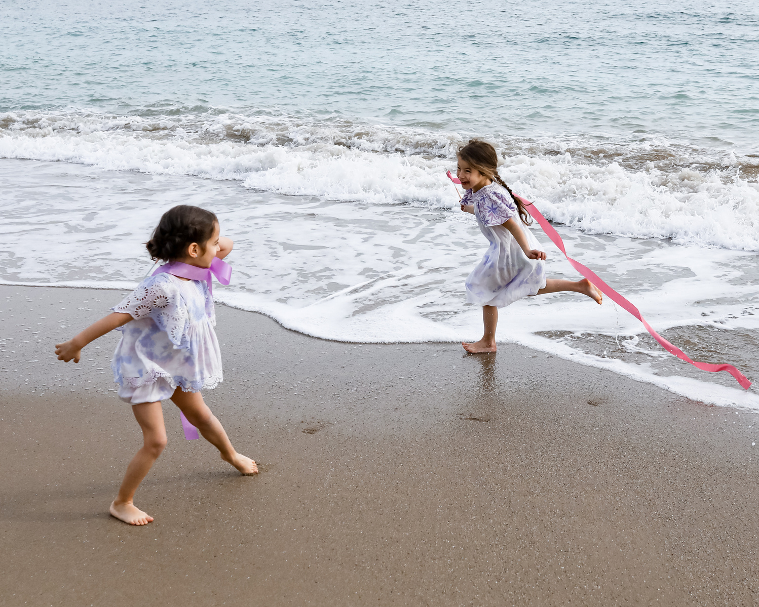 dos niñas jugando cerca del mar en la playa las casetas del Garraf en barcelona, españa