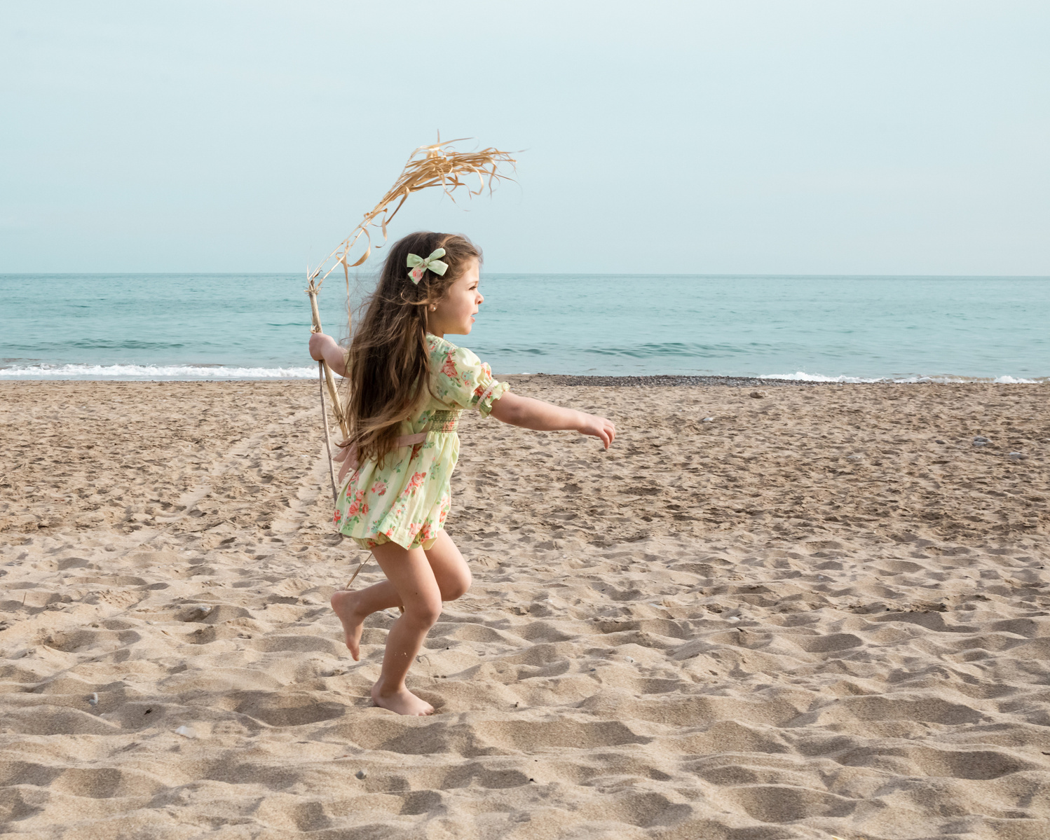 niña corriendo y jugando en la playa las casetas del Garraf en barcelona, españa