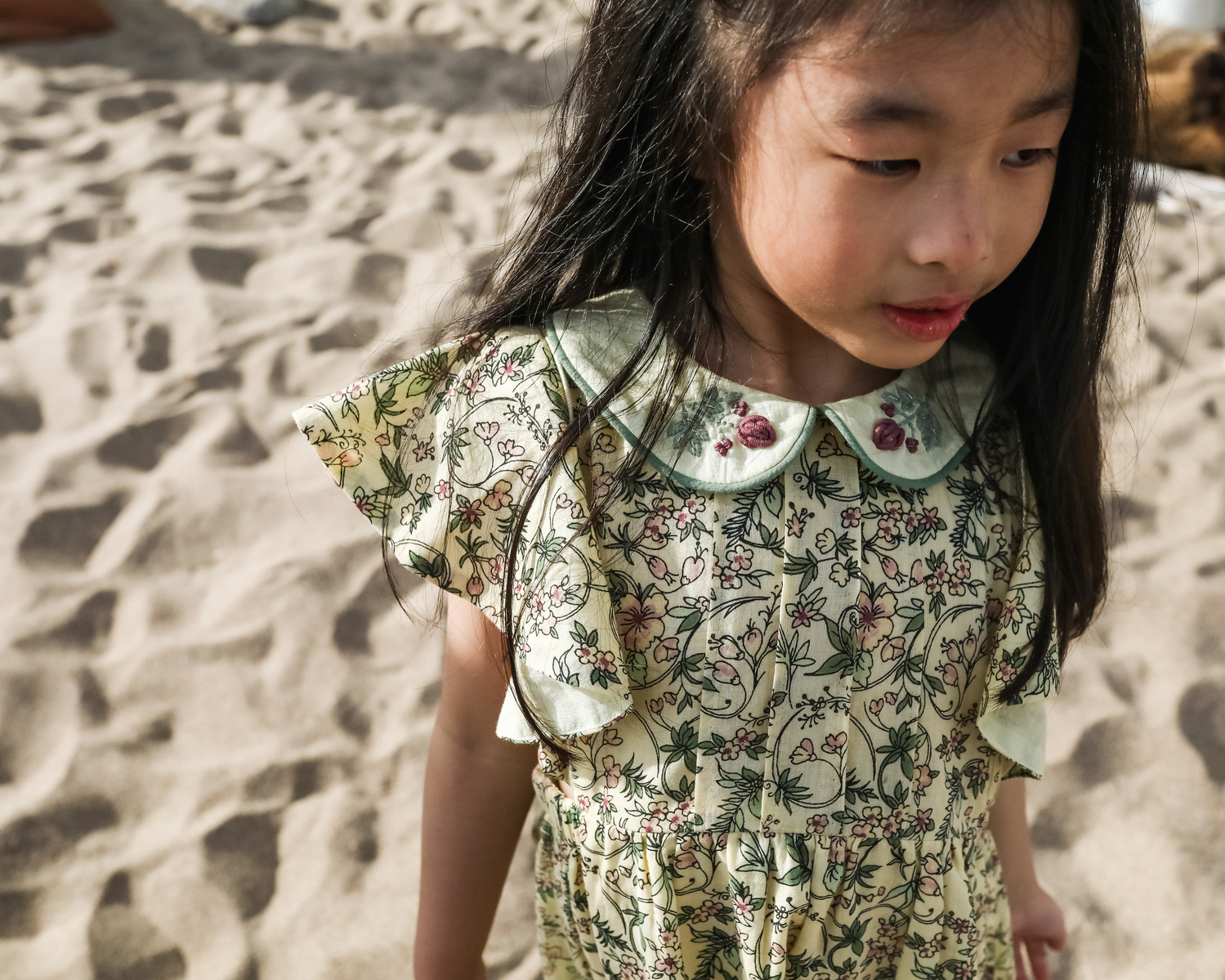retrato y detalle de vestido de una niña delante de les casetas del Garraf en Barcelona, españa