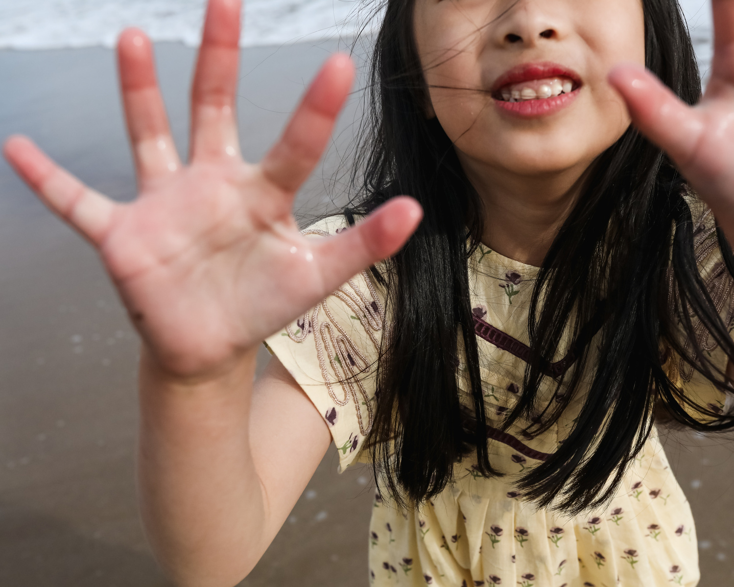 niña muestra sus manos en la orilla del mar de les casetas del Garraf en Barcelona, españa