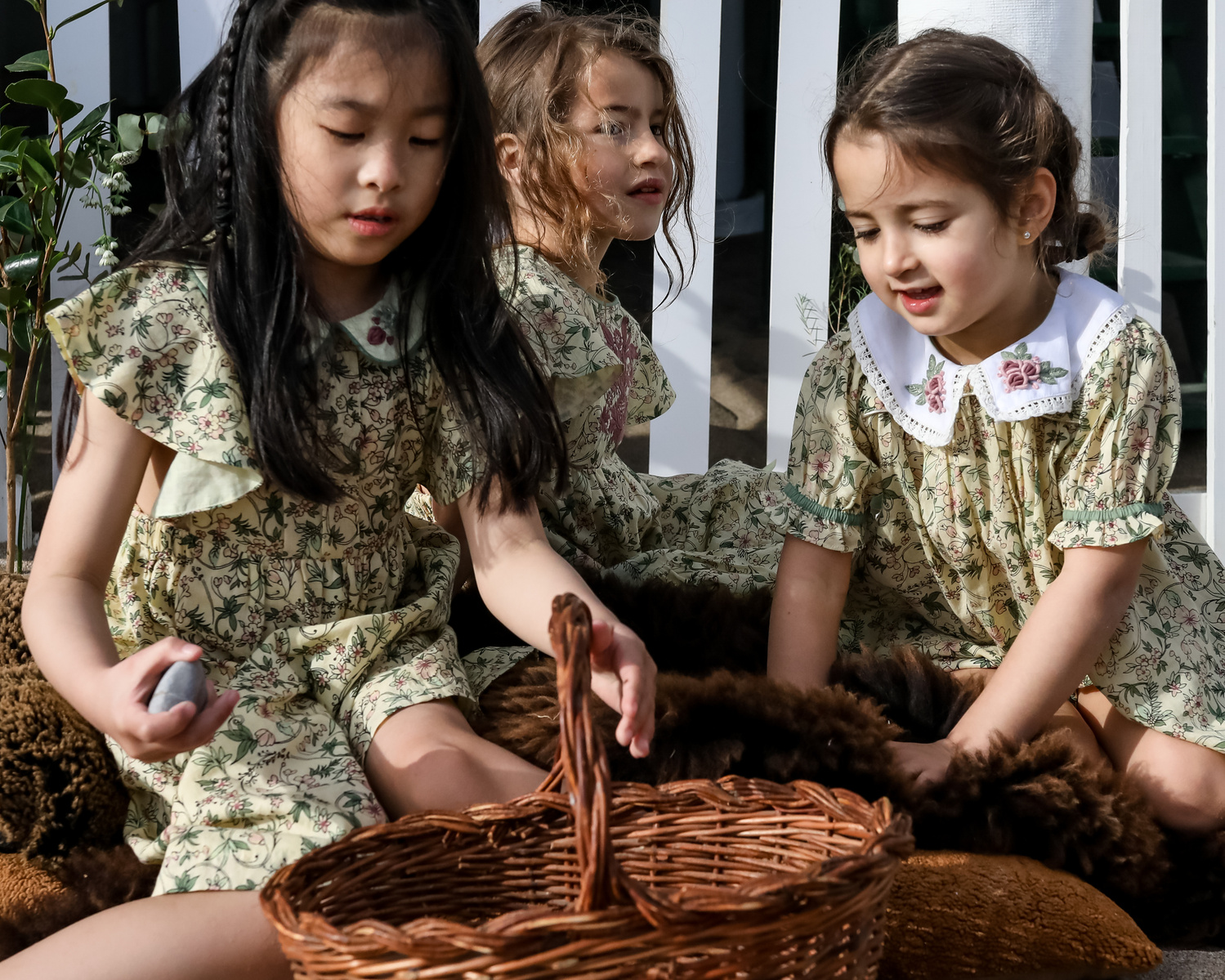 tres niñas con juegan delante de una de les casetas del Garraf en Barcelona, españa