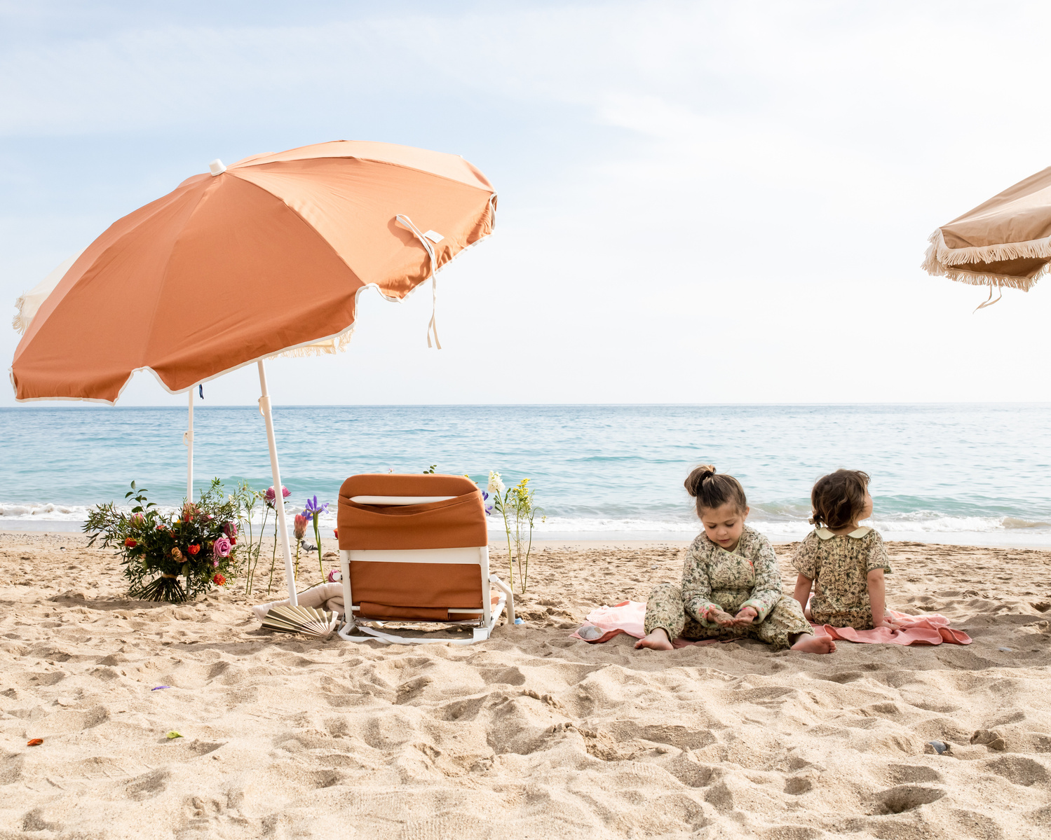 dos niñas y mobiliario de playa   en la playa las casetas del Garraf en barcelona, españa