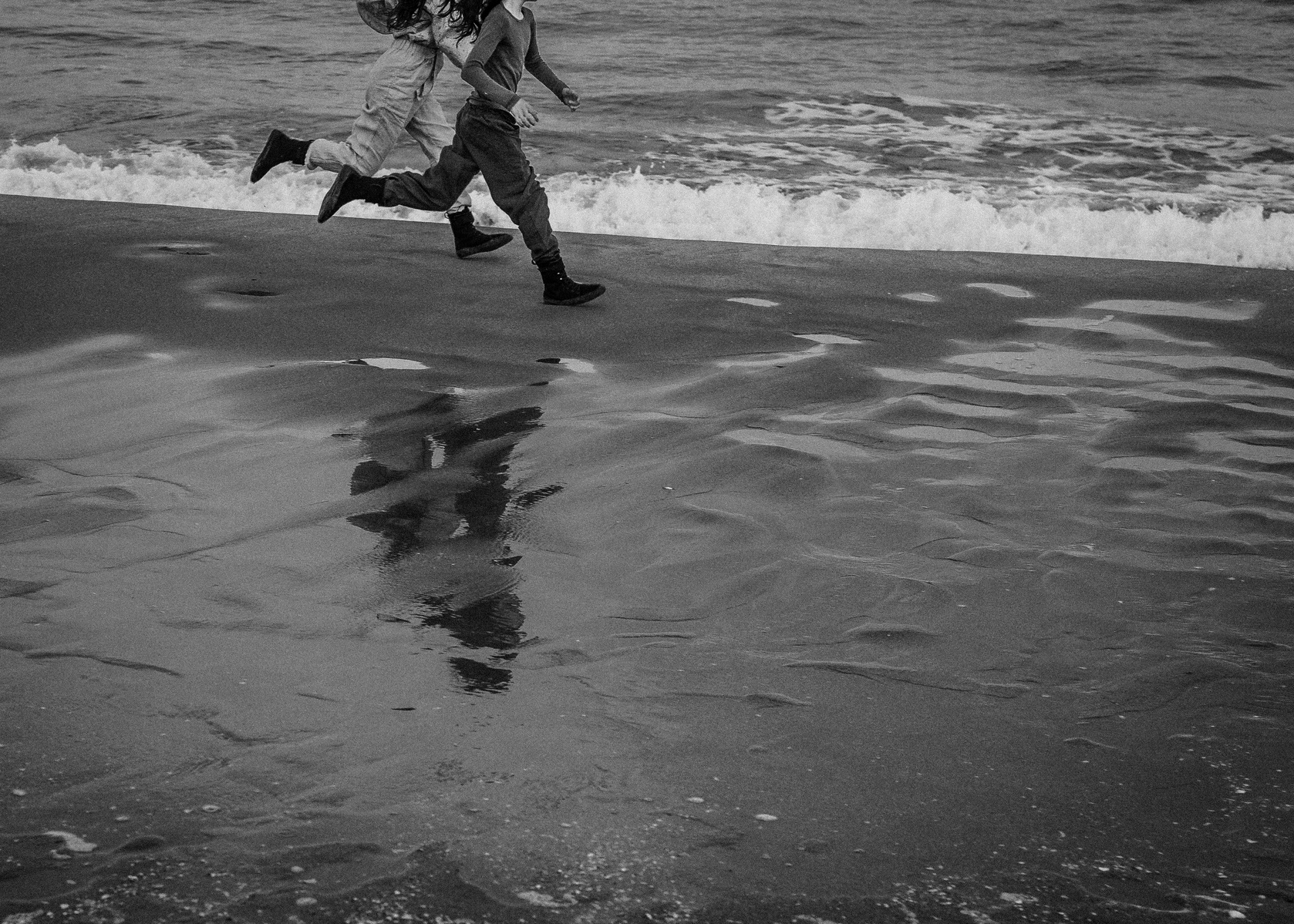 hermanos corriendo por la playa sant Pere pescador,  bahía de rosas, Catalunya 