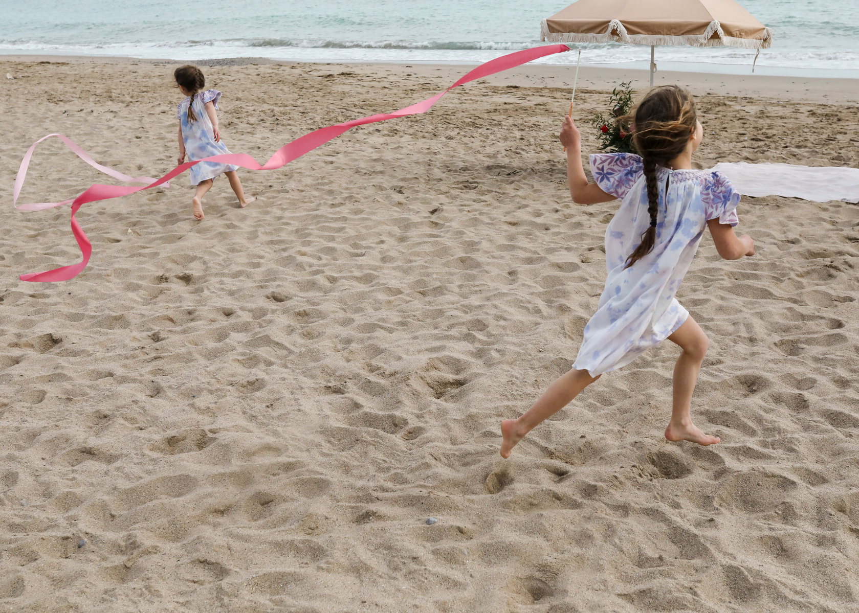 dos niñas corriendo felices la playa las casetas del Garraf en barcelona, españa