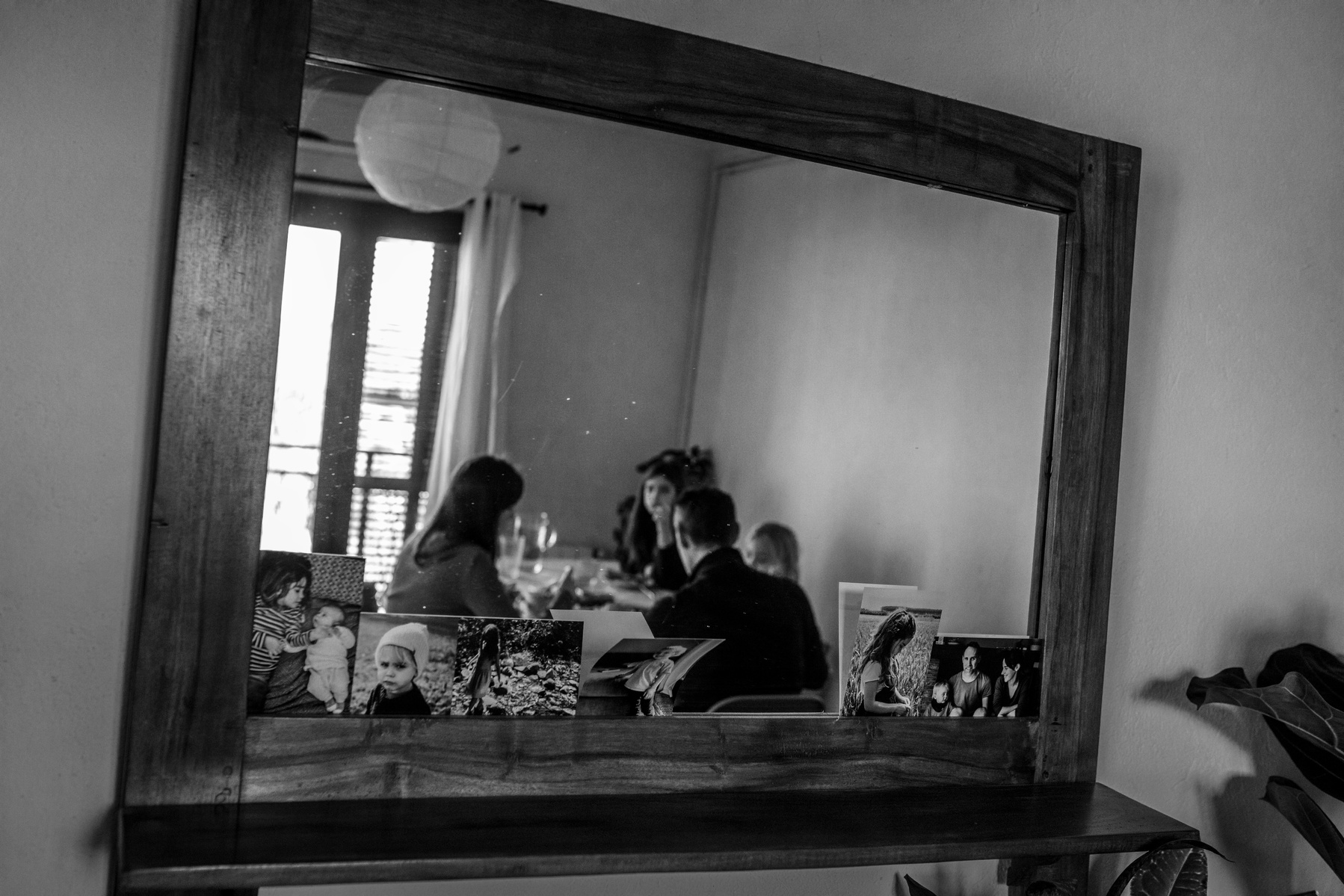 Reflejo en un espejo del salon de una familia comiendo.
Manuela Franjou family photography 