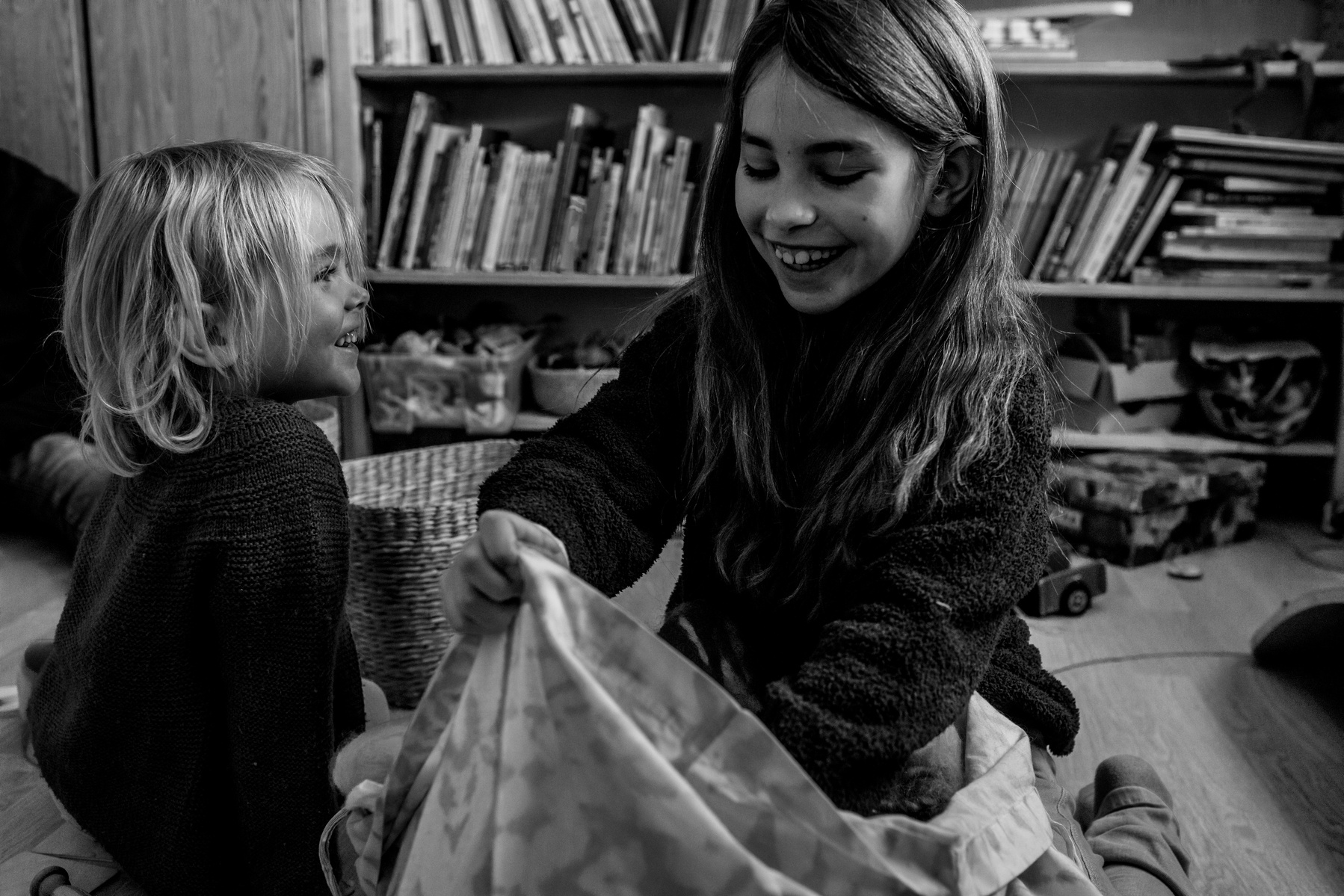 Hermana y hermano riendo en la habitación de juego.
Manuela Franjou family photography