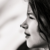 Retrato en blanco y negro, de una niña pequeña con una mariquita en la nariz