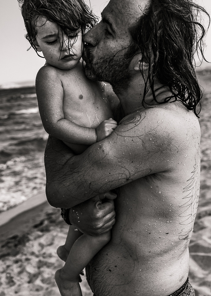 beso de un padre a su bebe, en la playa en sant Pere pescador, alt Empordá, Catalunya, españa