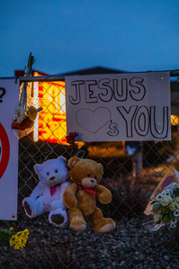 Teddy bears, posters, and flowers left in tribute hang on fence in front of King Soopers sign in Boulder, CO. (Io Hartman&amp;amp;#x2F;CU Independent)