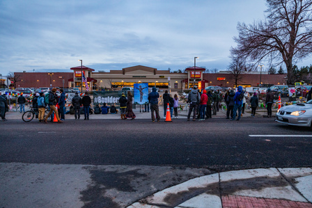 People gathered in front of fence at King Soopers on Table Mesa in Boulder, CO on Tuesday, March 23, 2021. (Io Hartman&amp;amp;#x2F;CU Independent)