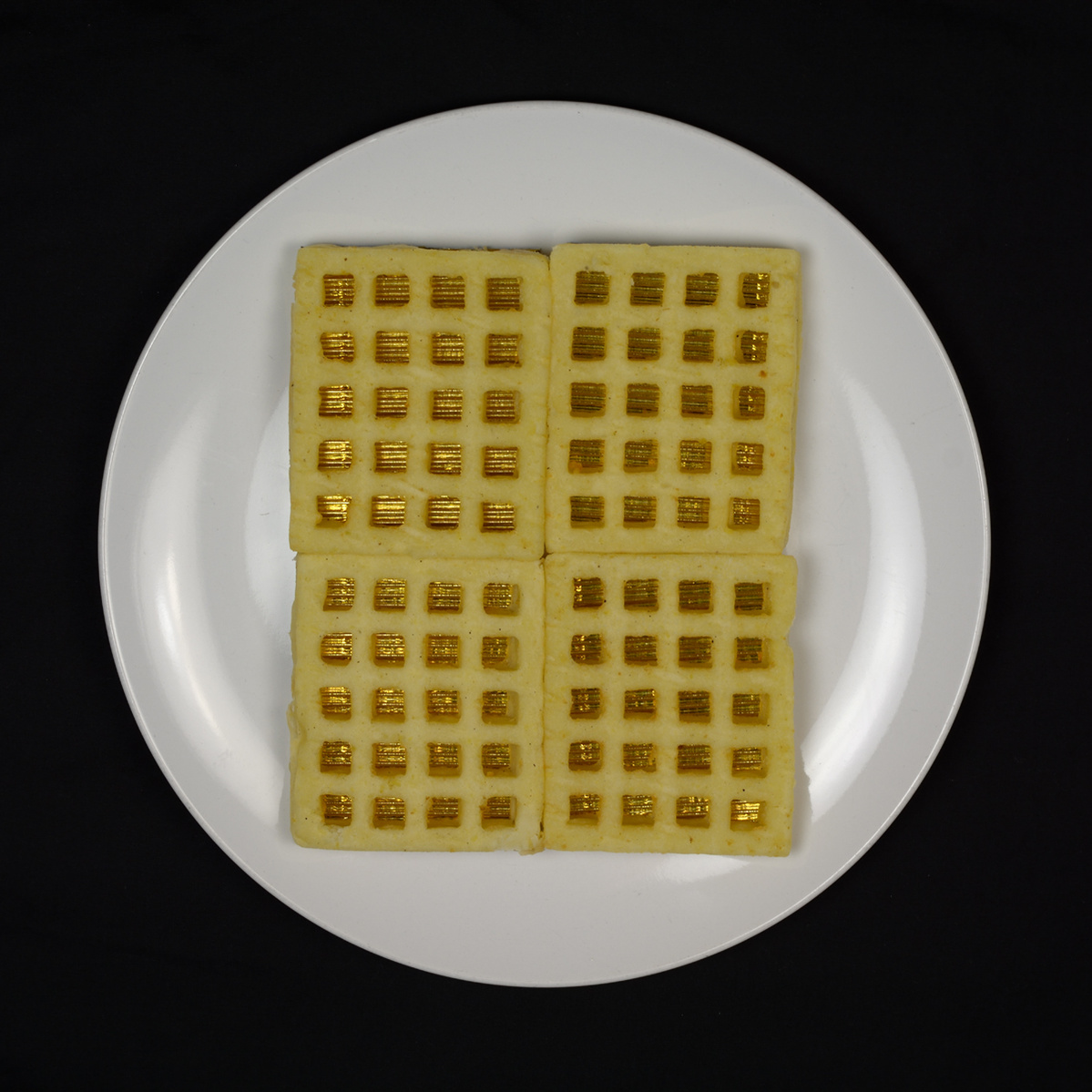 plate of potato waffles with gold showing through their grids