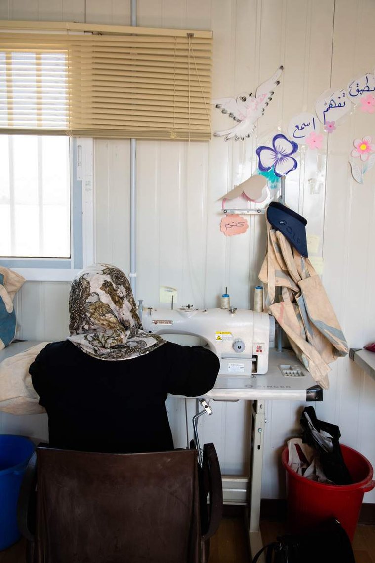 A Lel-Haya worker sews together UNHCR tent pieces that have been measured and cut to be made into reusable tote bags. 

