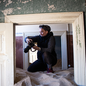 Environmental portrait- Photographer and journalist Lizane Louw. Photographer with a camera. Kolmanskop, Namibia