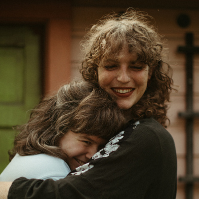 A queer couple snuggling in their backyard for engagement photos in Minneapolis MN.