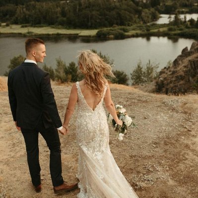A couple elopes on top of a small mountain overlooking the Columbia river gorge in the Summer.