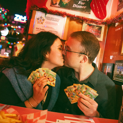 A cute couple taking their engagement photos at a dive bar while playing cards in Minneapolis.