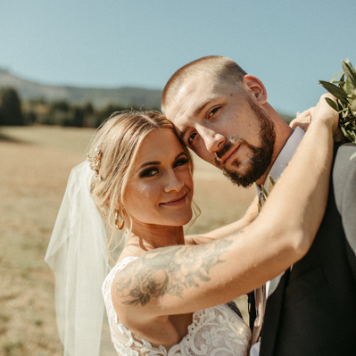 A styled couple on their Wedding day in the PNW under a bright blue sky.