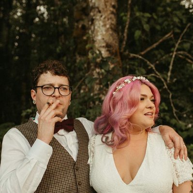 A couple smoking a blunt on their wedding day in Oregon with hot pink hair.