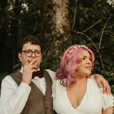 A couple smoking a blunt on their wedding day in Oregon with hot pink hair.