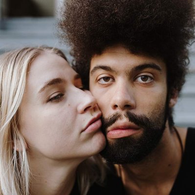 A cute young couple in editorial poses on their front porch.