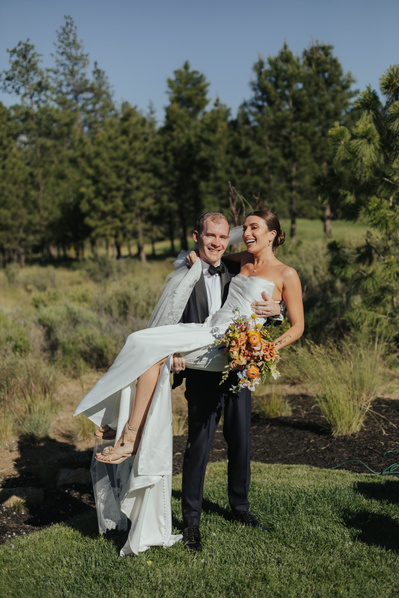 Groom picking up his bride during their backyard wedding