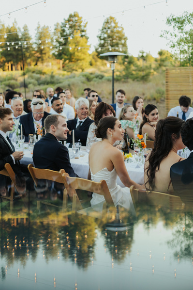 Couple listening to speeches at their backyard wedding in Oregon