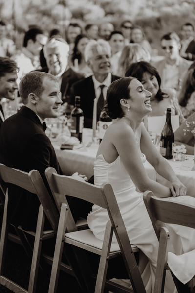 Bride and groom laughing during toasts at their wedding