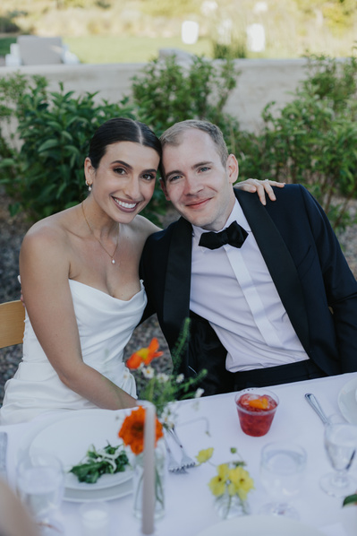 Couple posing for a photo at their reception table