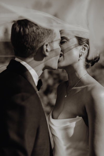 Bride and groom kissing under her veil 