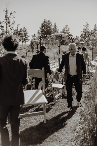 Guests carry their chairs to the reception at Tetherow wedding in Bend