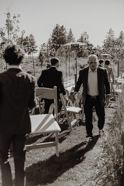 Guests carry their chairs to the reception at Tetherow wedding in Bend