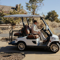 Photo of the groom driving a golf cart during his Brasada Ranch wedding in Oregon