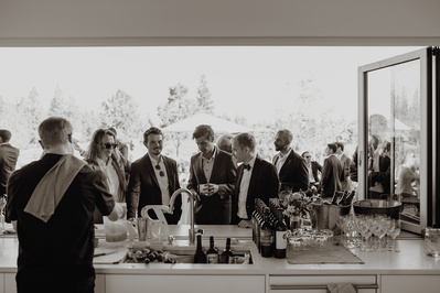 Groom talking with his friends at the bar during his wedding