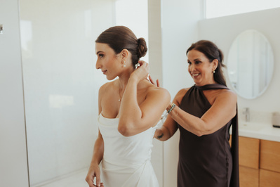 Bride gets wedding dress buttoned during Bend Oregon wedding