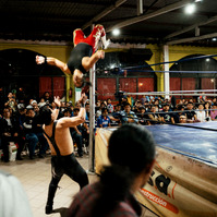 A luchador doing a back flip off the ropes of the ring in Oaxaca, Mexico.