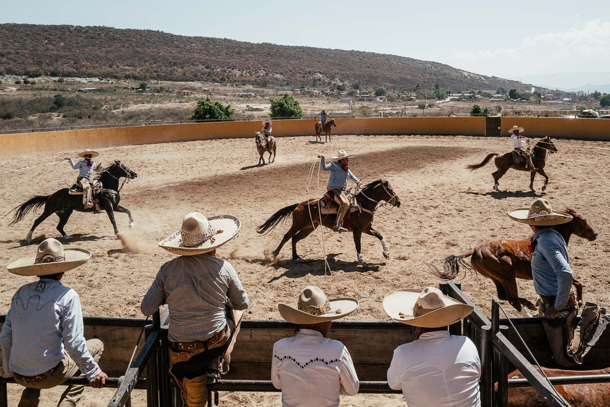 Charros performing on horses at a traditional Charrería in Oaxaca Mexico