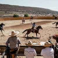 Charros performing on horses at a traditional Charrería in Oaxaca Mexico
