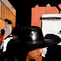 Two men in cowboy hats and a woman and child exiting a market in Oaxaca, Mexico
