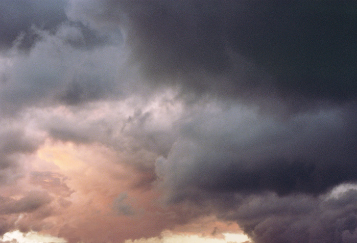 A soft and pale purple sky with storm clouds at dusk
