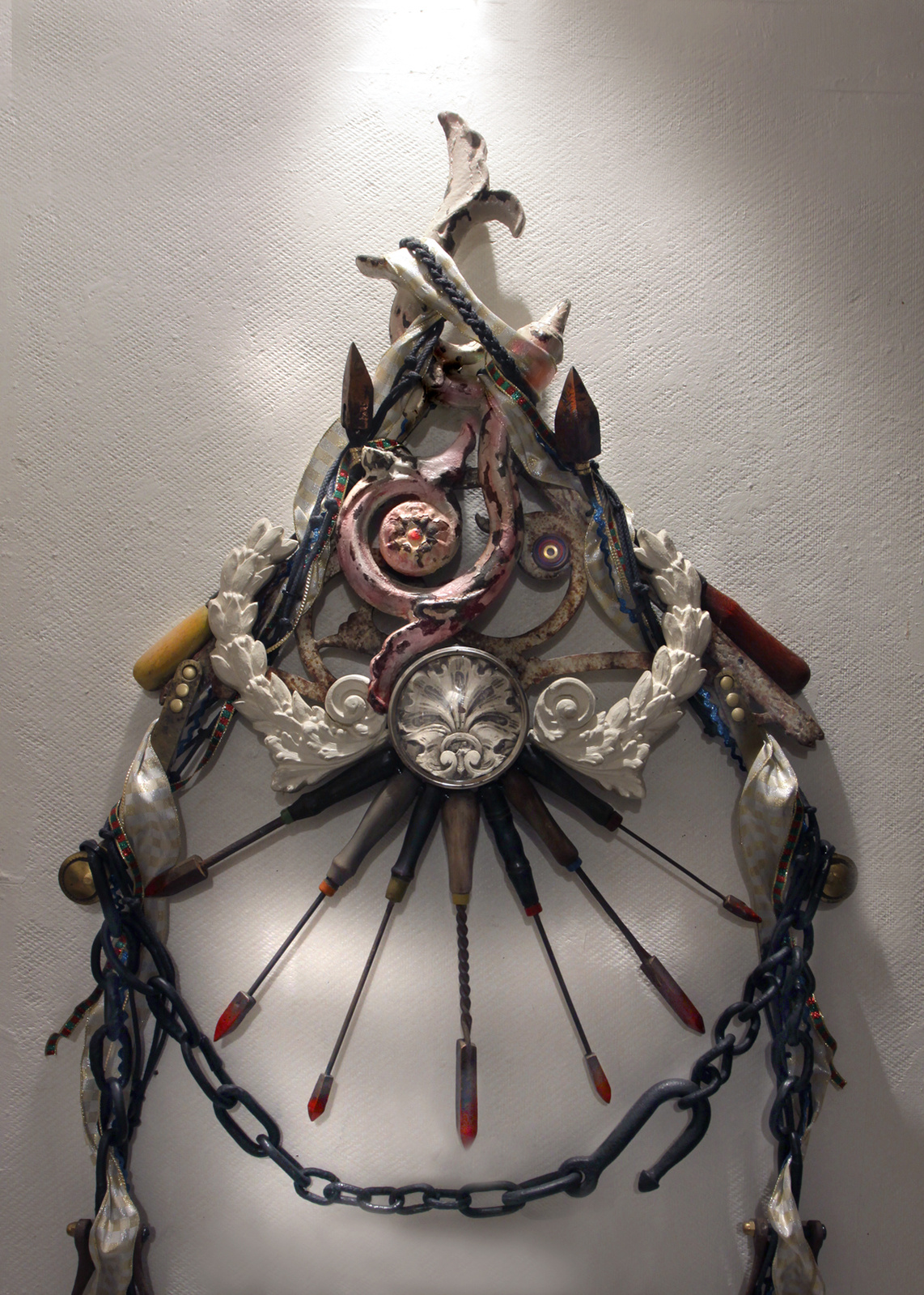 Wall assemblage referencing diverse religious iconography, devotion and penance. Detail, under directional lighting