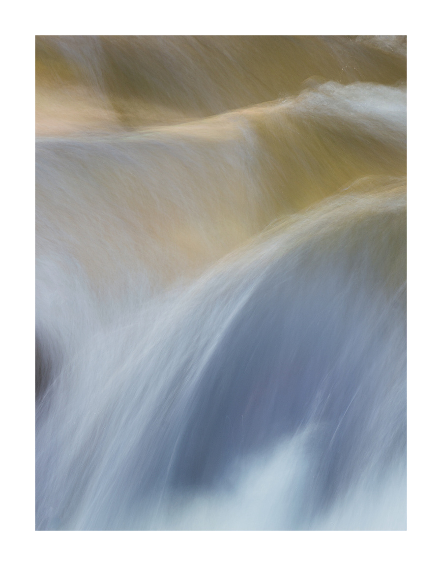 Abstract photograph in long exposure format of water rushing over boulders with border. Abstract photography prints