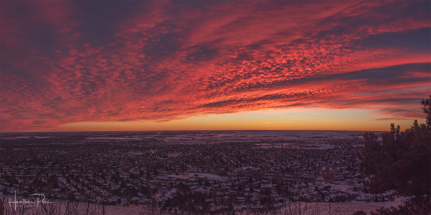 Sunrise photography of a blanket of clouds over a snowy boulder, colorado, pano