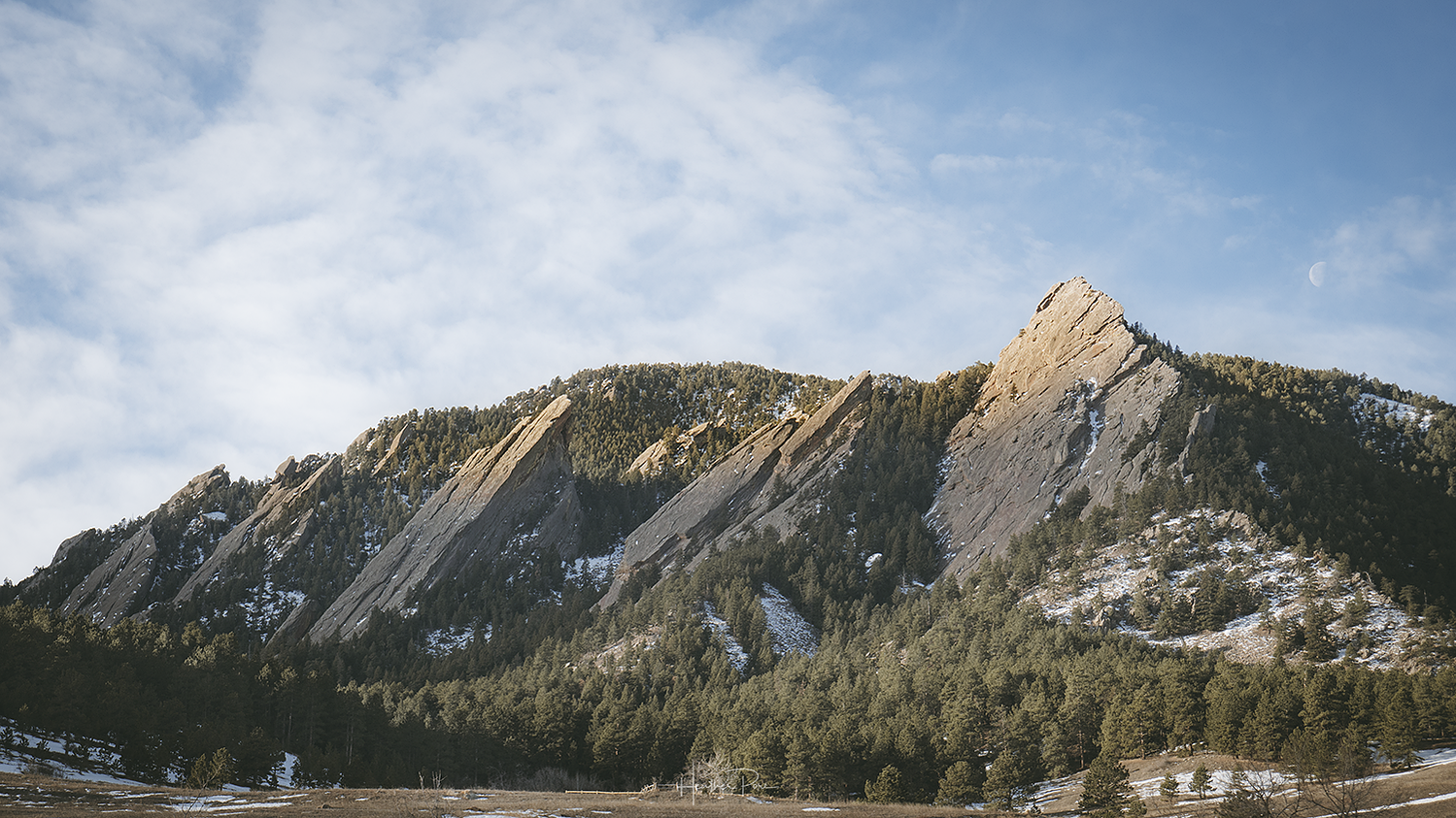 landscape photograph of flatirons in boulder, colorado as the morning sun starts to hit the very tops on a february morning