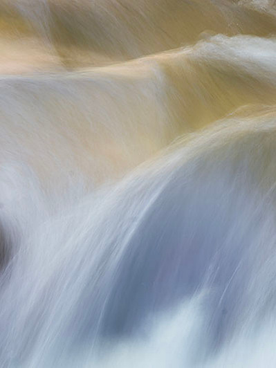 a long exposure close up water picture of water flowing over the rapids. abstract photography