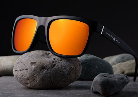 Sunglasses styled in studio with professional lighting. Composited to high light product's strong design and clean lines. Beautiful red/orange gradient shows off lenses.