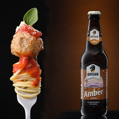 Composite image of spaghetti on a form and a frosty bottle of beer, both shot in studio with professional lighting. This high lights the power of professional food and product images.