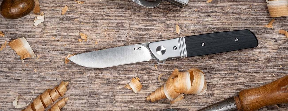Detailed pocket knife lying on workbench with sawdust and woodworking tool. Excellent styled product show with studio lighting and advanced editing and compositing techniques.