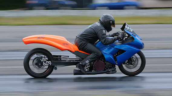 High-powered drag motorcycle in blue and orange, shot at the Bremerton Raceway, with motion blur in the background. Action photography like this is a specialized skill, but lots of fun.