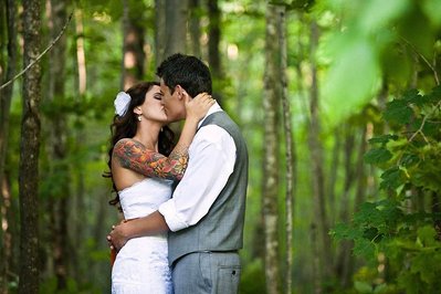 Couple posing in woods for their wedding photographer.